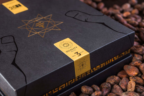 To'ak 50g Art Series Edition - a black and gold box rests on a bed of cacao beans